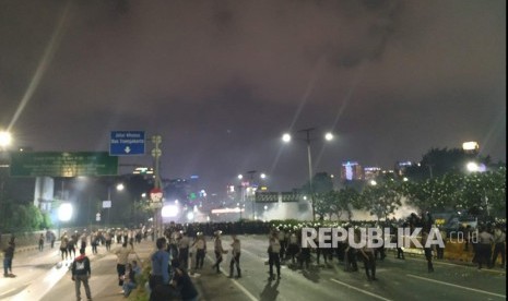 Massa pelajar mengalami kontak dengan aparat kepolisian saat dipukul mundur di Jalan Gatot Subroto ke arah Putaran Semanggi. Rabu (25/9) malam.