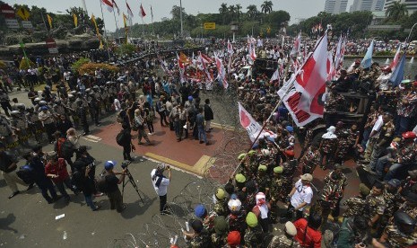 Massa pendukung pasangan capres dan cawapres Prabowo Subianto dan Hatta Rajasa saling berhadapan dengan polisi yang melakukan barikade di Jalan Medan Merdeka Barat, Jakarta, Kamis (21/8). 