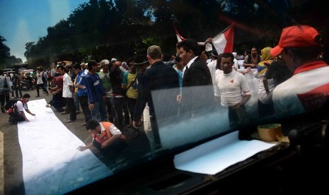 Massa pendukung Prabowo Subianto-Hatta Rajasa menandatangai kain putih saat berunjuk rasa di depan Gedung Mahkamah Konstitusi (MK), Jakarta Pusat, Jumat (25/7). 