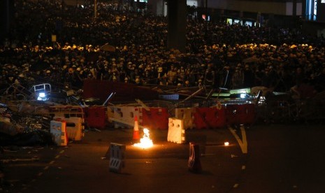 Massa penentang aturan ekstradisi berkumpul di belakang barikade di dekat kantor Dewan Legislatif di Hong Kong, Rabu malam (12/6). 