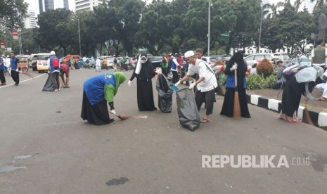 Massa peserta aksi,  membersihkan sampah pasca-aksi 313 di Jalan Medan Merdeka Barat , Jumat (31/3).