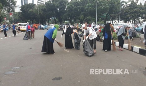 Massa peserta aksi membersihkan sampah pascaaksi 313 di Jalan Medan Merdeka Barat , Jumat (31/3).