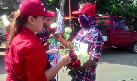 Massa pro Ahok membagi-bagikan pin dan bunga mawar merah dan putih di depan Gedung Kementerian Pertanian, Jakarta Selatan (9/5)