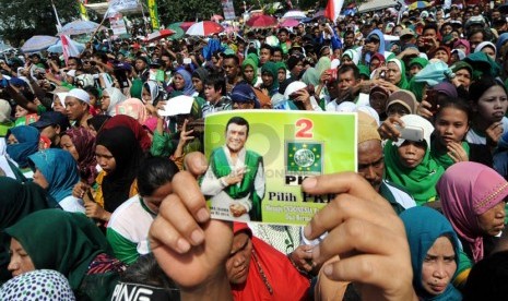   Massa simpatisan Partai Kebangkitan Bangsa (PKB) memegang stiker Rhoma Irama saat mengikuti kampanye terbuka di Pulo Mas, Jakarta, Senin (24/3). (Republika/Aditya Pradana Putra)