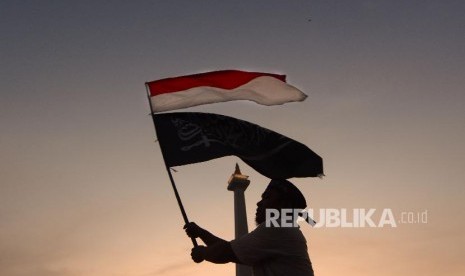 Massa yang tergabung dalam Alumni 212 mengibarkan bendera merah putih saat aksi reuni 212 di lapangan Monumen Nasional, Jakarta, Senin (2/12). 