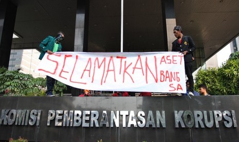 Massa yang tergabung dalam Forum Mahasiswa Peduli Aset Bangsa (FMPAB) membentangkan spanduk saat berunjuk rasa di depan gedung KPK, Jakarta, Jumat (20/11).