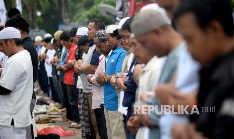 Massa yang tergabung dalam Gerakan Nasional Pengawal Fatwa (GNPF) MUI melakukan shalat Dzuhur saat berlangsungnya sidang penista Agama yang berlangsung di Auditorium Kementan, Jakarta, Selasa (24/1).