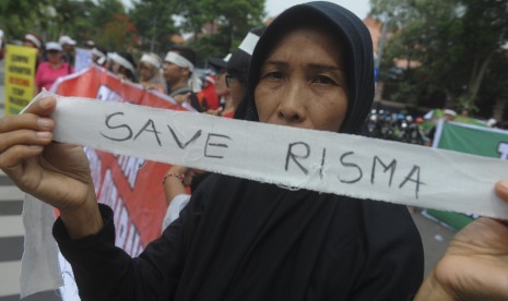 Massa yang tergabung dalam Suara Arek Surabaya membentangkan poster saat aksi menolak Risma dicalonkan dalam Pilgub Jatim di depan Balai Kota Surabaya, Jawa Timur, Senin (8/1). 