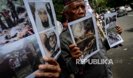  Massa yang tergabung dari Hizbuttahrir Indonesia menunjukan foto korban kekerasan terhadap Muslim Rohingya yang terjadi di Myanmar saat melakukan aksi di depan Kedutaan Besar Myanmar, Jakarta Pusat, Kamis (24/11).