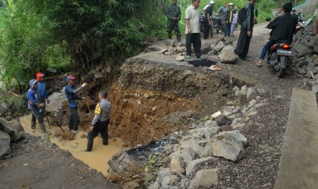 Masyarakat bergotongroyong memperbaiki jalan putus tergerus longsor bersamaan hujan deras mengguyur di Desa Bencoy, Cireunghas, Sukabumi, Jawa Barat, Minggu (29/10). Jalan yang amblas dan putus pada Sabtu (28/10) petang itu merupakan jalan alternatif dari Sukabumi menuju obyek wisata Situs Prasejarah Gunung Padang di Kecamatan Campaka, Cianjur.