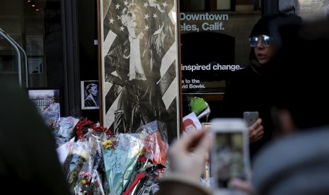 Masyarakat melewati memorial mengenal meninggalnya David Bowie di kawasan Manhattan, New York.