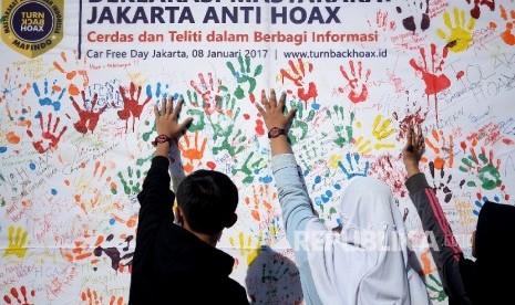 Masyarakat membubuhkan cap tangan saat kegiatan sosialisasi sekaligus deklarasi masyarakat anti hoax di Jakarta,Ahad (8/1).