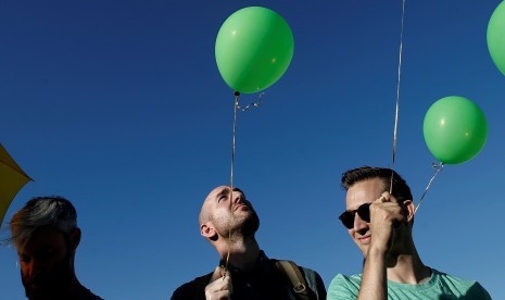 Masyarakat memegang balon dalam acara mengenang korban penembakan Orlando di Jembatan Brooklyn, New York.