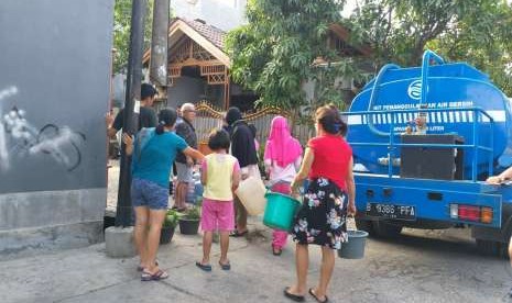 Masyarakat mengerubungi truk tangki air bersih.