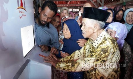 Masyarakat miskin  sedang mencoba fasilitas mesin ATM beras (Ilustrasi)