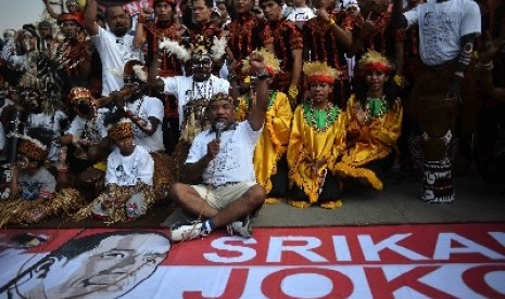 Masyarakat Papua mengenakan pakaian aadat menggelar aksi sebagai dukungannya terhadap Jokowi di Bundaran HI, Jakarta, Ahad (18/5). 