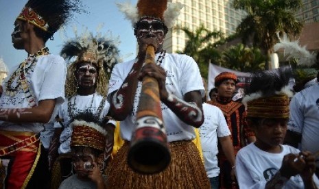 Masyarakat Papua mengenakan pakaian aadat menggelar aksi sebagai dukungannya terhadap Jokowi di Bundaran HI, Jakarta, Ahad (18/5). 