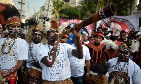 Masyarakat Papua mengenakan pakaian adat menggelar aksi sebagai dukungannya terhadap Jokowi di Bundaran HI, Jakarta, Ahad (18/5). 