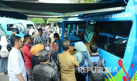 Masyarakat termasuk di antaranya mahasiswa ITB antre saat pelayanan perekaman KTP elektronik cepat di sejumlah mobil Dinas Kependudukan dan Catatan Sipil (Disdukcapil) Kota Bandung di halaman kampus ITB, Senin (26/2).