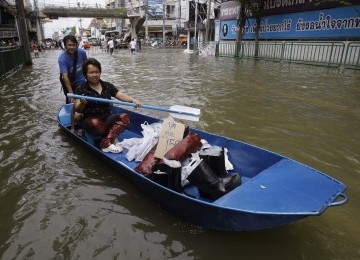 Masyarakat Thailand berdagang dengan menggunakan perahu di tengah kota Bangkok, Jumat, 28/10. (AP)