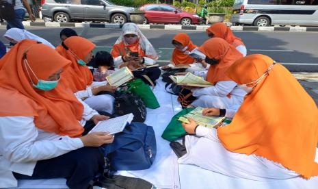 Masyarakat yang terdiri dari emak-emak, bapak-bapak serta pemuda dan pemudi di Kota Bandung membaca Alquran 30 juz serentak on the road di Jalan Ir. H. Djuanda, Selasa (19/4/2022). Kegiatan tersebut dilakukan sebagai bentuk syiar di bulan puasa Ramadhan. Manfaat Lahir dan Batin di Balik Perintah Puasa