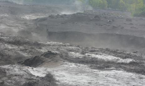 Material lahar hujan Gunung Semeru mengalir di Kali Regoyo, Desa Sumberwuluh, Candipuro, Lumajang, Jawa Timur, Minggu (9/1/2022). Lahar hujan erupsi Gunung Semeru terjadi akibat curah hujan yang tinggi di kawasan lereng gunung, membawa material pasir, kerikil dan batu yang masih mengancam warga di sepanjang aliran sungai.