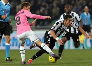 Mauricio Isla (kanan), pemain Udinese asal Chile, berebut bola dengan pemain Juventus, Claudio Marchisio, di laga Seri A Italia di Stadion Friuli, Udinese, Rabu (21/12). 