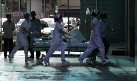 Medical personnel transport a victim of a factory explosion, at a hospital in Kunshan, Jiangsu province, August 2, 2014. 