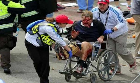   Medical workers aid an injured man at the 2013 Boston Marathon following an explosion in Boston, Monday, April 15, 2013