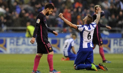 Megabintang Barcelona Lionel Messi (kiri) berjalan melewati pemain Deportivo La Coruna Raul Albentosa seteah kalah 1-2 di Riazor, Ahad (12/3).