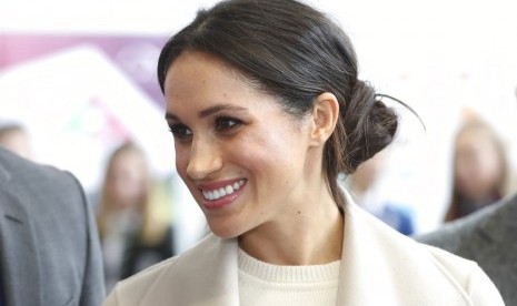 Meghan Markle saat mendampingi Pangeran Harry di Irlandia Utara. Rambutnya ditata agak berantakan, sesuatu yang melawan tradisi Istana Buckingham.