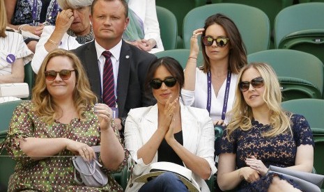 Meghan Markle (tengah) bertepuk tangan memberi dukungan pada petenis Serena Williams yang bertanding di laga Wimbledon, Kamis (4/7), di London, Inggris.