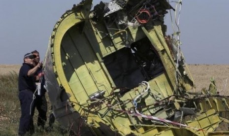 Members of a group of international experts inspect wreckage at the site where the downed Malaysia Airlines flight MH17 crashed, near the village of Hrabove (Grabovo) in Donetsk region, eastern Ukraine August 1, 2014.