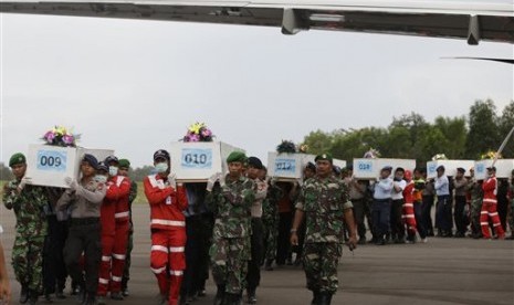 Members of the National Search And Rescue Agency carry coffins containing bodies of the victims aboard AirAsia Flight 8501 to transfer to Surabaya at the airport in Pangkalan Bun, Indonesia, Friday, Jan. 2, 2015. 