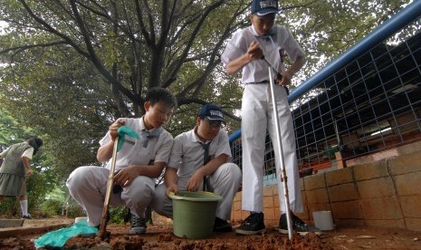 Membuat lubang biopori.