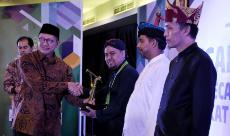 Menag menyerahkan tropy kepada juara KUA Kecamatan Teladan Tingkat Nasional 2019 