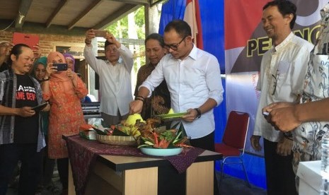 Menaker Hanif Dakhiri memotong tumpeng sebagai tanda dimulainya kerja sama dengan SPPQT, Selasa (9/8).