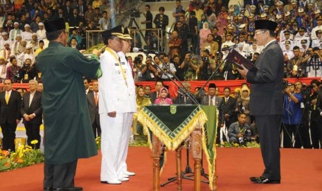 Mendagri Gamawan Fauzi (kanan) mengambil sumpah Gubernur Riau terpilih Annas Maamun (kedua kiri) dan wakilnya Arsyadjuliandi Rahman (ketiga kiri) pada pelantkan Gubernur Riau di Pekanbaru, Rabu (19/2). 