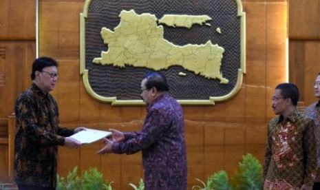 Mendagri Tjahjo Kumolo (kiri) menyerahkan surat perintah pada Gubernur Jawa Timur Soekarwo (tengah) disaksikan Pelaksana tugas (Plt) Wali Kota Batu Jawa Timur Punjul Santoso (kanan) di Gedung Negara Grahadi Surabaya, Jawa Timur, Senin (18/9). Punjul meneruskan tugas Wali Kota Batu Jawa Timur Eddy Rumpoko yang ditangkap KPK dalam Operasi Tangkap Tangan (OTT) terkait dugaan kasus suap pembangunan proyek pengadaan meubel di Pemkot Batu tahun anggaran 2017.