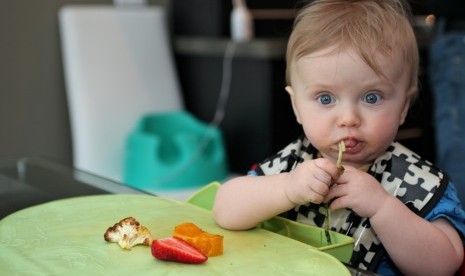 Bayi sedang makan.