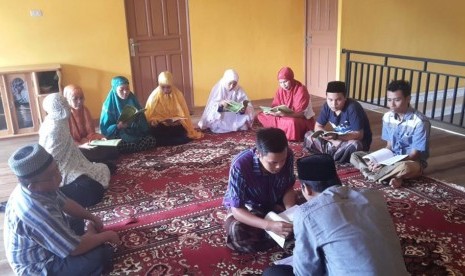 Mengaji dan belajar membaca Alquran.