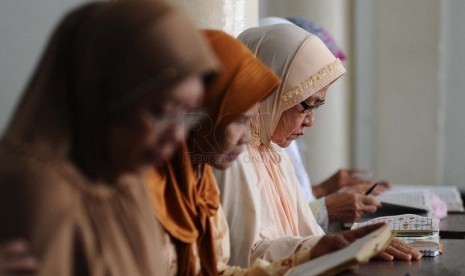 Mengaji Warga sedang membaca ayat suci al-Quran di Majelis Ta'lim Al-Falaah, Jakarta, Selasa (18/3). 