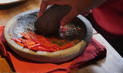 Mengulek sambal.