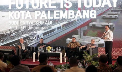 Menhub Budi Karya Sumadi (berdiri) bersama Gubernur Sumatera Selatan Alex Noerdin dan pengamat transportasi Yayat Supriana menjadi pembicara pada sosialisasi 'Payo Naik LRT, Life Style Baru Wong Kito,' di Palembang, Rabu (1/8), yang dipandu pakar manajemen Rhenald Kasali.