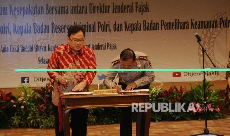 Menkeu Bambang Brodjonegoro (kiri), Kapolri Badrodin Haiti melakukan penandatanganan Addendum Nota Kesepahaman di kantor Pusat Pajak, Jakarta, Selasa (19/1).