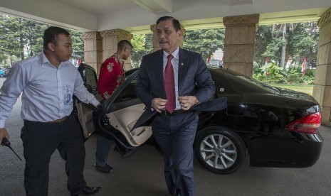 Menko Maritim dan Sumber Daya selaku Plt Menteri ESDM Luhut Binsar Pandjaitan (kanan) turun dari kendaraan dinasnya saat tiba di Kementerian ESDM, Jakarta, Selasa (16/8).