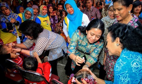 Menko Pembangunan Manusia dan Kebudayaan Puan Maharani (ketiga kanan) dan Menteri Kesehatan, Nila F. Moeloek (kedua kiri), disaksikan Ibu Negara, Iriana Joko Widodo (kanan) memberikan vaksin polio tetes kepada anak balita seusai Pencanangan Pekan Imunisasi