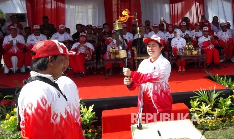 Menko Pemberdayaan Manusia dan Kebudayaan, Puan Maharani menyerahkan api PON/2016 Jabar kepada atlet legendaris angkat berat asal Indramayu Darma, di halaman Pendopo Indramayu, Senin (5/9). (Republika/Lilis Sri Handayani)