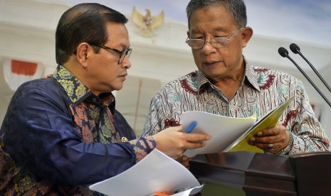 Menko Perekonomian Darmin Nasution (kanan) berdiskusi dengan Sekretaris Kabinet Pramono Anung (kiri) saat memaparkan Paket Kebijakan Ekonomi Tahap XI di Kantor Presiden, Jakarta, Selasa (29/3).