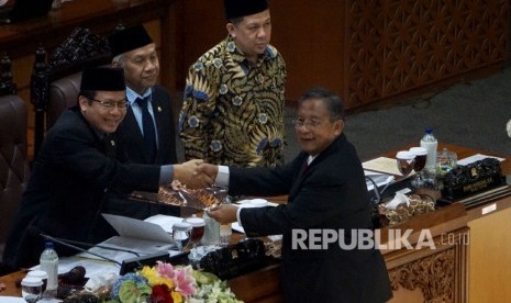 Menko Perekonomian Darmin Nasution memberikan laporan kepada Wakil Ketua DPR sekaligus pimpinan rapat Paripurna DPR Taufik Kurniawan didampingi Wakil Ketua DPR Agus Hermanto (kedua Kanan) dan Fahri Hamzah (kiri) pada sidang Paripurna ke-29 DPR di Gedung Nusantara II, Kompleks Parlemen, Senayan, Jakarta, Kamis (6/7).